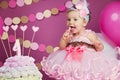 Portrait of a little cheerful birthday girl with the first cake. Eating the first cake. Smash cake Royalty Free Stock Photo