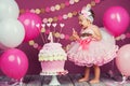 Portrait of a little cheerful birthday girl with the first cake. Eating the first cake. Smash cake Royalty Free Stock Photo