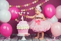 Portrait of a little cheerful birthday girl with the first cake. Eating the first cake. Smash cake Royalty Free Stock Photo