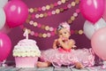 Portrait of a little cheerful birthday girl with the first cake. Eating the first cake. Smash cake Royalty Free Stock Photo