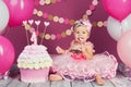 Portrait of a little cheerful birthday girl with the first cake. Eating the first cake. Smash cake Royalty Free Stock Photo