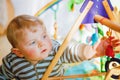 Portrait of little child, cute adorable baby boy playing with colorful toys. Happy, curious kid at home, indoors. Royalty Free Stock Photo