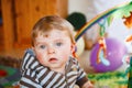 Portrait of little child, cute adorable baby boy playing with colorful toys. Happy, curious kid at home, indoors. Royalty Free Stock Photo