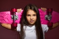 little child girl holding pink skateboard