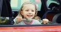 Portrait little child passenger sitting in a red car