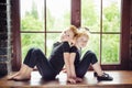 Portrait of 2 little children dancer girl and boy in black leotard sitting on window at dance studio. Recovery on dancing lesson. Royalty Free Stock Photo