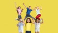 Portrait of little children jumping isolated on yellow studio background with copyspace Royalty Free Stock Photo