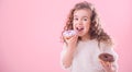 Portrait of a little curly girl eating donuts Royalty Free Stock Photo