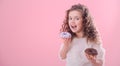 Portrait of a little curly girl eating donuts Royalty Free Stock Photo