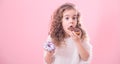 Portrait of a little curly girl eating donuts Royalty Free Stock Photo