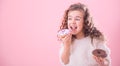 Portrait of a little curly girl eating donuts Royalty Free Stock Photo