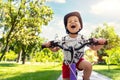 Portrait little cute adorable caucasian toddler boy in safety helmet enjoy having fun riding exercise bike in city park Royalty Free Stock Photo