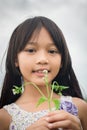 Portrait of Little cute asian girl holding flower among the purple flower field look at the camera, freedom Royalty Free Stock Photo