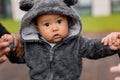 Portrait of little cute baby boy making first steps, holding hands of father and mother, looking at the camera Royalty Free Stock Photo