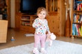 Portrait of little cute baby girl learning walking and standing. Adorable toddler girl at home Royalty Free Stock Photo