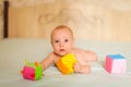 Portrait of little cute five month old caucasian baby lies on his stomach and plays with soft cubes in selective focus Royalty Free Stock Photo