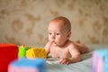 Portrait of little cute five month old caucasian baby lies on his stomach and plays with soft cubes in selective focus Royalty Free Stock Photo