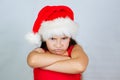 portrait of a little cute girl in a Christmas hat is very unhappy and angry