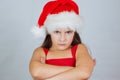 portrait of a little cute girl in a Christmas hat is very unhappy and angry Royalty Free Stock Photo