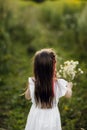 Portrait little cute girl with flowers. Girl in the garden with a bouquet of chamomile Royalty Free Stock Photo