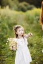 Portrait little cute girl with flowers. Girl in the garden with a bouquet of chamomile Royalty Free Stock Photo