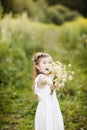 Portrait little cute girl with flowers. Girl in the garden with a bouquet of chamomile Royalty Free Stock Photo