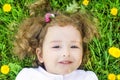 Portrait of little cute girl lying with dandelions on the grass. child with flowers outdoors Royalty Free Stock Photo