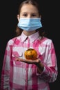 Portrait of a little cute girl with a medical mask isolated on black background Royalty Free Stock Photo