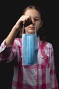 Portrait of a little cute girl with a medical mask isolated on black background Royalty Free Stock Photo