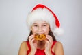 portrait little cute girl in santa hat eating christmas cookies Royalty Free Stock Photo