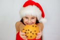 portrait little cute girl in santa hat eating christmas cookies Royalty Free Stock Photo