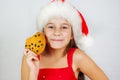 portrait little cute girl in santa hat eating christmas cookies Royalty Free Stock Photo