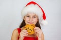 portrait little cute girl in santa hat eating christmas cookies Royalty Free Stock Photo