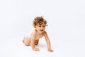 Portrait of little cute toddler boy, baby in diaper crawling isolated over white studio background Royalty Free Stock Photo