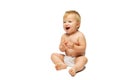 Portrait of little cute toddler boy, baby in diaper sitting isolated over white studio background. Infectious laughter Royalty Free Stock Photo