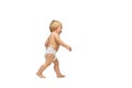 Portrait of little cute toddler boy, baby in diaper walking isolated over white studio background. First steps Royalty Free Stock Photo