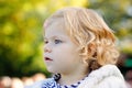 Portrait of little cute toddler girl sitting in stroller or pram and going for a walk. Happy cute baby child having fun Royalty Free Stock Photo
