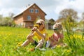 Portrait of little fair-haired boy and girl with bouquet of dandelions. Brother and sister in the meadow near the house Royalty Free Stock Photo