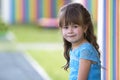 Portrait of little fashionable blond girl in blue dress, with gr