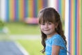 Portrait of little fashionable blond girl in blue dress, with gr