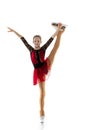 Portrait of little flexible girl, figure skater wearing stage attire posing isolated on white studio background. Concept