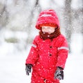 Portrait of little boy in red winter clothes having fun with snow during snowfall Royalty Free Stock Photo