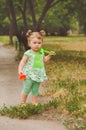 Portrait of a little girl in the alley with a toy