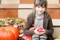 Portrait of little girl with apple and pumpkin