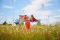 Portrait of little girl with Asian eyes and butterfly wings having fun and joy in meadow or field with grass and flowers Royalty Free Stock Photo