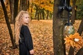 Portrait of little girl in autumn. the child looks at tree and mask with respirator with plants. ecology concept