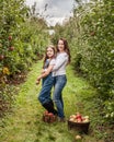 Portrait of little girl and beautiful mother in organic apple orchard happy and having fun Royalty Free Stock Photo