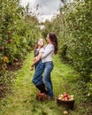 Portrait of little girl and beautiful mother in organic apple orchard happy and having fun Royalty Free Stock Photo