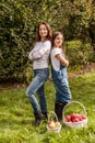 Portrait of little girl and beautiful mother in organic apple orchard happy and having fun Royalty Free Stock Photo