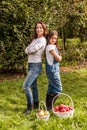 Portrait of little girl and beautiful mother in organic apple orchard happy and having fun Royalty Free Stock Photo